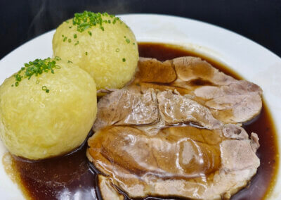 Schweinebraten mit Klößen angerichtet auf einem Teller